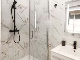 A bathroom with a shower and sink at Tudno Lodge in Llandudno