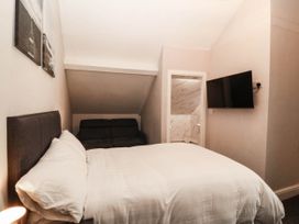 A bedroom with a bed and a sofa at Tudno Lodge in Llandudno