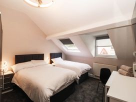 A bedroom with two beds and a desk at Tudno Lodge in Llandudno