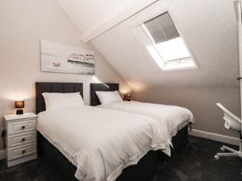 A bedroom with two single beds and a nightstand at Tudno Lodge Llandudno