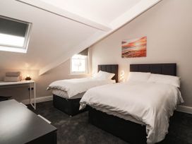 A bedroom with two beds and a nightstand at Tudno Lodge in Llandudno