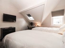 A bedroom with two beds and a television at Tudno Lodge in Llandudno