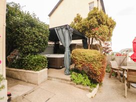A garden with a hot tub and seating area at Tudno Lodge in Llandudno
