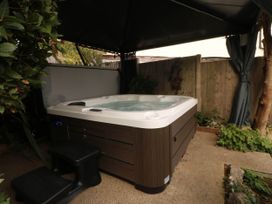 An outdoor area with hot tub under a canopy at Tudno Lodge in Llandudno