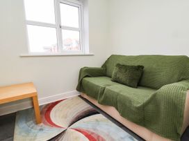 A living room with a green sofa and a wooden table at 64 Derwent Road in Whitby