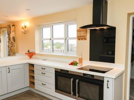 A kitchen with appliances and a window at 64 Derwent Road Whitby