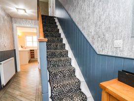 A hallway with a staircase and doorway leading to a kitchen at 64 Derwent Road Whitby