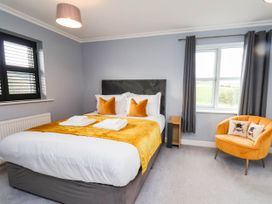 A bedroom with a bed and chair at 64 Derwent Road, Whitby