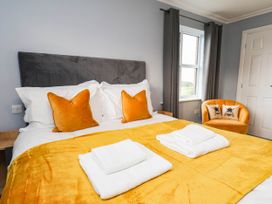 A bedroom with a bed and orange chair at 64 Derwent Road in Whitby