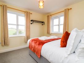 A bedroom with a bed and windows at 64 Derwent Road in Whitby