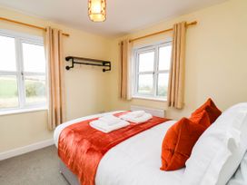 A bedroom with a bed and windows at 64 Derwent Road Whitby
