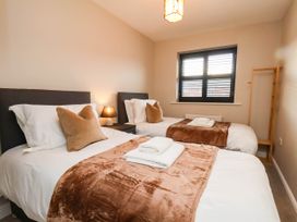 A bedroom with two beds and a window at 64 Derwent Road in Whitby