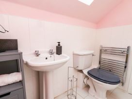 A bathroom with wash basin, toilet and towel warmer at 64 Derwent Road in Whitby