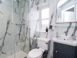 A bathroom with a shower, toilet, and sink at 64 Derwent Road Whitby