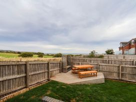 A garden with a wooden deck and table at 64 Derwent Road in Whitby