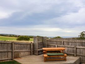 A garden with a wooden deck and seating area at 64 Derwent Road, Whitby