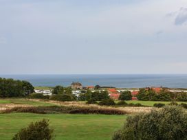 A view of the ocean, houses, and trees at 64 Derwent Road in Whitby