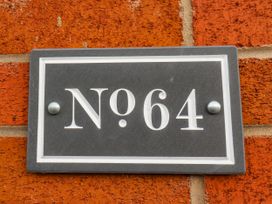 A number plaque on a brick wall at 64 Derwent Road Whitby