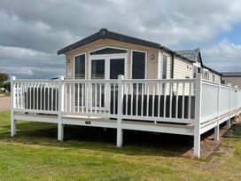 A static caravan with decking and railing at Silversands Holiday Park, Indi’s Retreat at Silversands in Helston