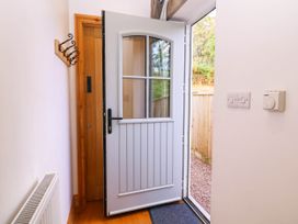 An entrance hall with a door and coat hooks at The Burrow at Aveling Cottage in Lydney