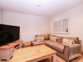 A living room with a sofa and television at The burrow at Aveling Cottage in Lydney