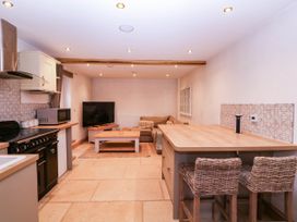 A kitchen with a sofa and television at The burrow at Aveling Cottage in Lydney