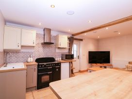 A kitchen with a sink stove and television at The burrow at Aveling Cottage in Lydney