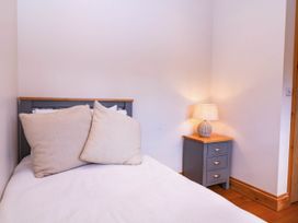 A bedroom with a bed and bedside table lamp at The burrow at Aveling Cottage Lydney