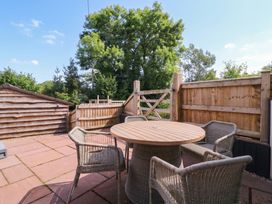A garden with a round table and chairs at The burrow at Aveling Cottage in Lydney