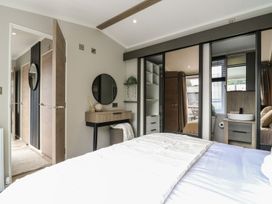 A bedroom with a bed and a mirror at Lakewood Plot 7 Clacton-on-Sea