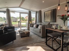 A living room with a sofa and dining table at Lakewood Plot 7 St. Osyth