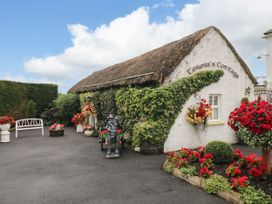 An outdoor area featuring flowers and a cottage sign at Teresa's Cottage