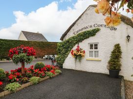 A garden with flowers and a cottage at Teresa's Cottage