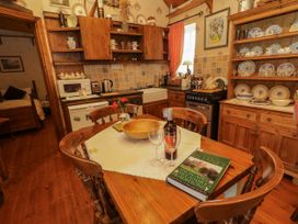 A kitchen with wooden furniture and kitchen appliances at Teresa's Cottage