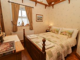A bedroom with a bed and a window at Teresa's Cottage