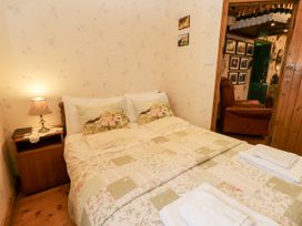 A bedroom with a double bed and bedside table at Teresa's Cottage
