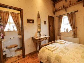 A bedroom with a bed and adjacent bathroom at Teresa's Cottage