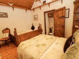 A bedroom with two beds and a doorway to a bathroom at Teresa's Cottage