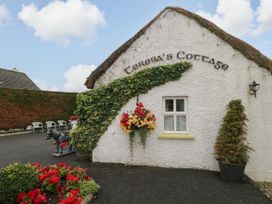 An exterior view of Teresa's Cottage with flowers and a horse statue in a garden