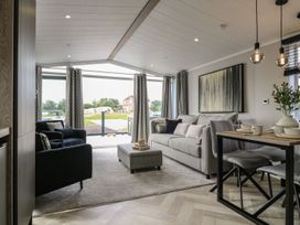 A living room with a sofa and dining table at Lakewood Plot 9 in Clacton-on-Sea