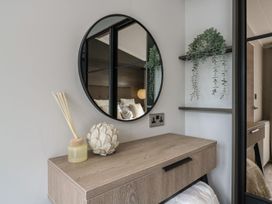 A bedroom with a mirror and decorative items at Lakewood Plot 9 in Clacton-on-Sea