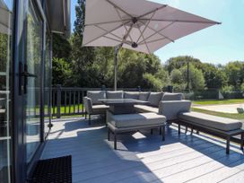 An outdoor patio with a sofa and table at Lakewood Plot 9 in St. Osyth