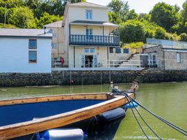 A house with a balcony and boat in the water at Shipwrights in Brixham