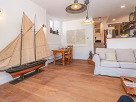 A living room with a ship model and dining table at Shipwrights in Brixham