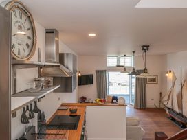 A kitchen with modern appliances and a view at Shipwrights in Brixham