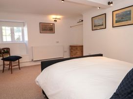 A bedroom with a bed and a dresser at Shipwrights in Brixham