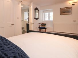 A bedroom with a bed and chair at Shipwrights Brixham