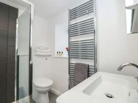 A bathroom featuring a shower, toilet, sink and towels at Shipwrights in Brixham