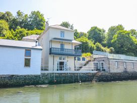 A house with a balcony and steps by the water at Shipwrights in Brixham