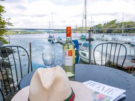 An outdoor area with a wine bottle and glasses overlooking water and boats at Spanish Boathouse in Brixham